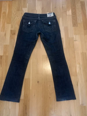 True religion jeans - Ett par jättefina mörkblåa true religion jeans i storlek 26. Köpte dem här på plick, önska jag kunde ha kvar dem men dem är tyvärr för stora. I bra skick förutom söndrig dragkedja i gylfen.  Innerbenslängd: 75cm Midjemått: 36 cm Fri frakt!