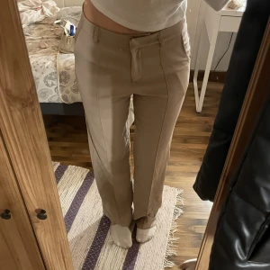 Madlady kostymbyxor  - Ett par beige kostymbyxor ifrån madlady i storlek L De är använda fåtal gånger, fint skick. De är långa i benen på mig som är 175