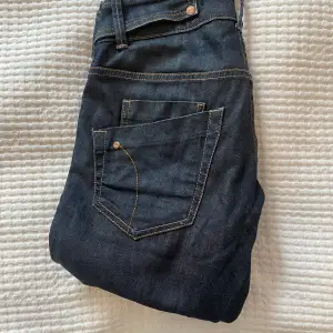 Lågmidjade jeans från Gina tricot (gamla) med design vid midjan och bakfickorna. 
