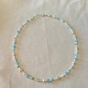 Handgjort pärlhalsband  - Superfint handgjort pärlhalsband i blå/peach/grön/vit🌿 perfekt nu i sommar! Längd: ca 49cm