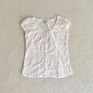 Vit kortärmad blus - Topp i luftigt randigt tyg och med fina banddetaljer, från märket Limited Too! Är i barnstorlek L så är som en XS, tyvärr lite för liten för mig 🤎