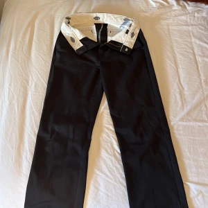 Kostymbyxor - Säljer mina Dickies kostymbyxor som är jättesnygga men som inte kommer till användning längre. Storlek W27 och passar superfint på mig som brukar ha storlek 36/38 på byxorna. Kostymbyxorna är i bra skick. Köparen står för frakt.