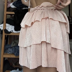 Plisserad volangkjol - Plisserad volangkjol med glittrigt tyg från nakd i strl XS! NYSKICK💕 jag är 171 cm lång! 😚 använd gärna köp nu🥰 går inte att få tag på längre!!! Går oxkså att använda som topp!