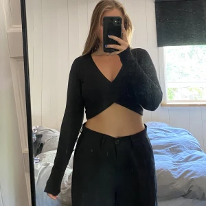 Svart croptop - Svart croptop från Bikbok med korsning fram över bröstet, väldigt smickrande. Användt skick