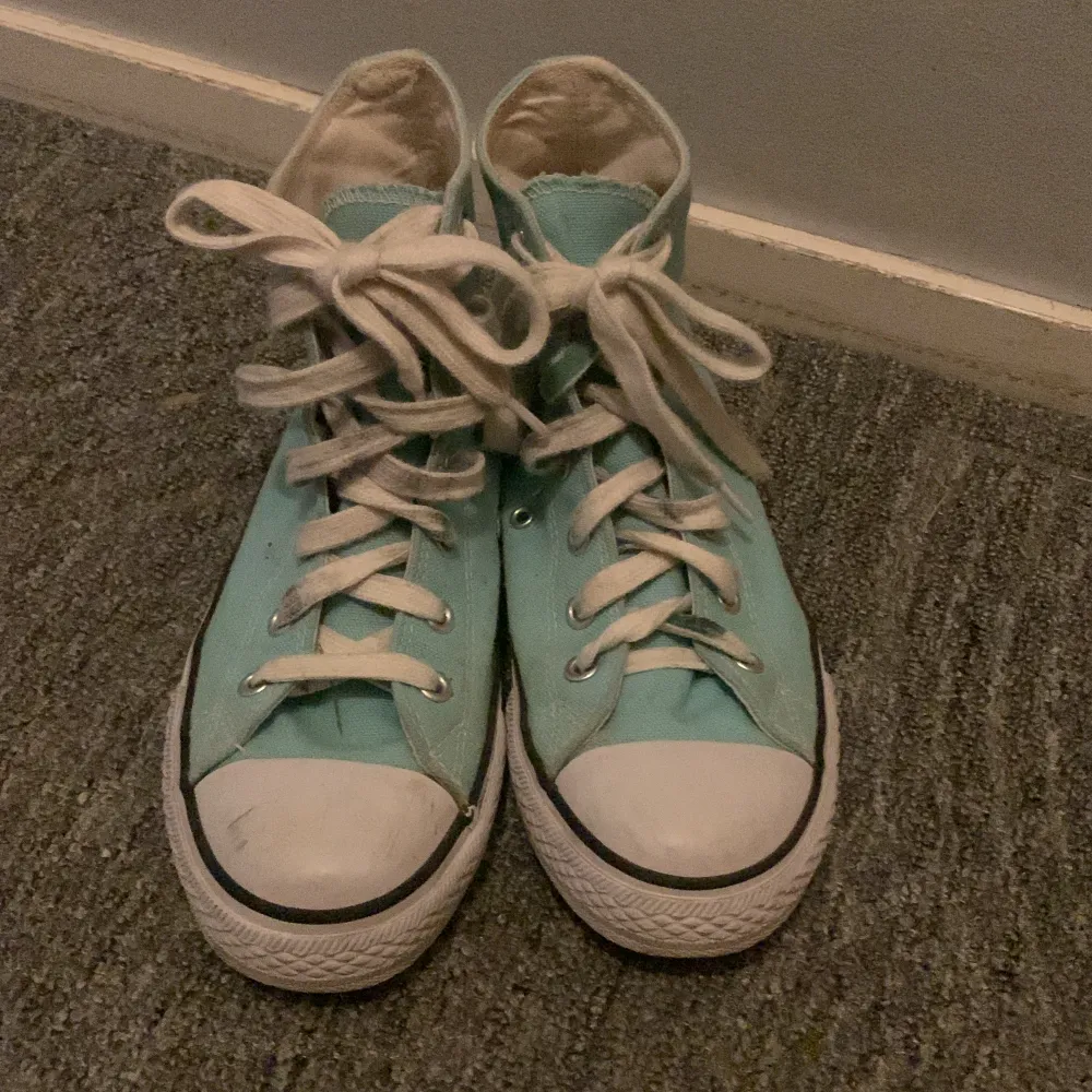 Säljer ett par nästan oanvända basketkängor i mintgrön (ljusturkos) canvastyg med vit gummisula. Liknar Converse klassiska All Star-modell. Strl 36 Inköpt för 250 kr, säljes för 100 kr.. Skor.