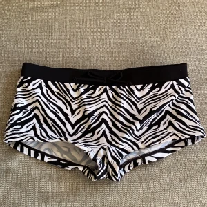 Badkläder - De svarta badshortsen är i storlekarna 34 och 36, säljs för 30kr styck, använda men är i nyskick. Bikinin är i storleken 152 och säljs för 100kr, använts 1 gång. De svartvita badshortsen är i storleken 146 och säljs för 30kr, aldrig använts.