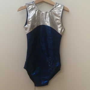 Gymnastikdräkt  - En tävlingsdräkt som är i bra skick med fina detaljer i glitter, det står tyvärr ingen storlek i dräkten förutom att det är en 3a och det motsvarar storleken 146-152. 