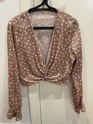 Beige blus från Chiquelle - Säljer denna eleganta och söta blus från Chiquelle. Aldrig använd. 🤎 Liten scrunch nertill vid handen (se bild)  Materialet är i silke.  Nypris: 399:- Mitt pris: 150:- 