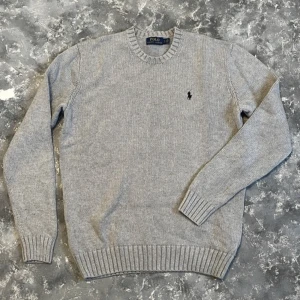 Stickad Ralph Lauren - Säljer denna grå stickade tröja från Ralph Lauren då den ej kommer till användning mer. Tröjan är i fint skick utan defekter. Ifall frågor dyker upp hojta till!