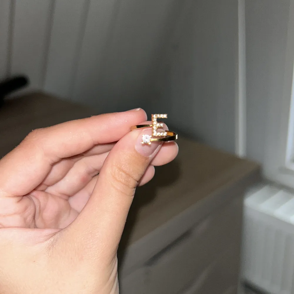 Guld ring med ett E . Accessoarer.