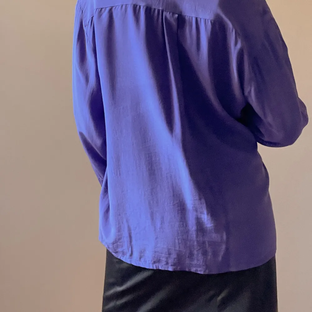 Purple Blouse with Silk Covered Buttons. Soft handfeel. Some light wear and fading of color as it’s a vintage piece.  100% Silk  Flatlay Measurements 63cm Length 55cm Sleeve 46cm Shoulder to Shoulder 110cm Chest 110cm Waist. Toppar.