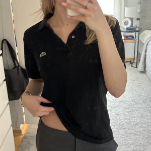 Lacoste Tröja - Thriftad svart Lacoste tröja i storlek 3 UK (ungefär 36 EU). Använd fåtal gånger av mig men är i väldigt fint skick!