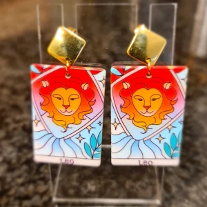 Örhängen lejonet. Stjärntecken.  - Örhängen av akryl och rostfritt stål. Lätta. Oanvända. 