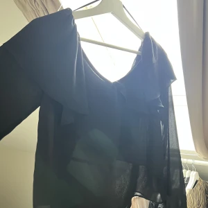 Svart blus - En svart superfin blus med liten volang upptill. Från Gina Tricot i storlek 34. Knappast använd.