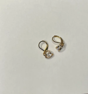 Guldiga örhängen  - Egengjorda örhängen, i guld med 2 stycken hjärtan. 