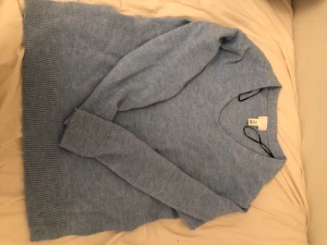 Blå stickad tröja  - Den har en liten fläck som man ser på bild 2. Annars i bra skick