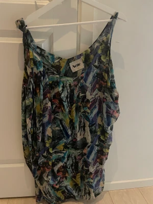 Acne klänning - Acne klänning i multifärger, tvistad i ena ärmen. Stl 36