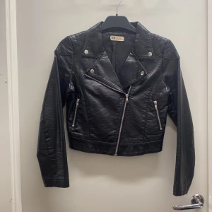 Skinnjacka/ Bikerjacka -  En skinnjacka i läderimitation i utmärkt skick utan några skador. Jackan är köpt från H&M och kostade ursprungligen 249 kr, men jag säljer den nu för 99 kr. Priset är förhandlingsbart. Om du är intresserad, så kan jag ge fler bilder eller ge dig mer info