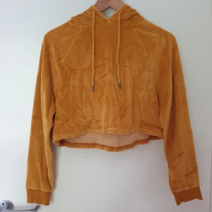 Cropped hoodie i sammet - Senapsgul croppad hoodie i sammet med luva. Från märket GDB från Urban Outfitters.   I använt skick.  Varm och mysig! Material är hälften bomull och hälften polyester. Luftig oversized modell.
