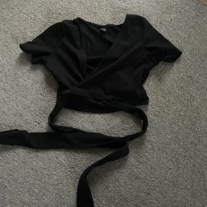 Topp - Svart topp med knytdetaljer som knappt använts därför jag nu säljer den