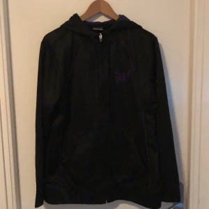 Tapout hoodie - En hoodie med kombination av svart och lila. Mjukt Tränings material så den andas bra och är jätteskön. Synd att den ba inte passar mig/: