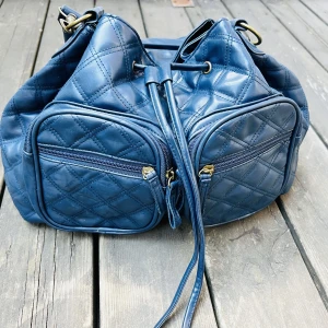 Dam väska i skin säljes - Superfin dam väska i skin.  Helt ny /oanvänd.  Yttre och inre fack finns.  Färg mörk (burgundy) blå. 