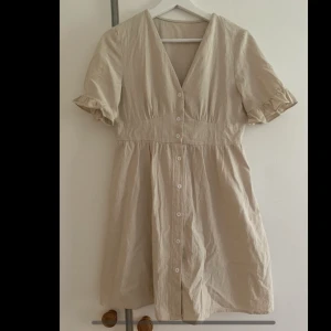 Klänning - Beige klänning i linne-imiterat tyg. Endast använd ett par gånger, så i nyskick. Storlek S.