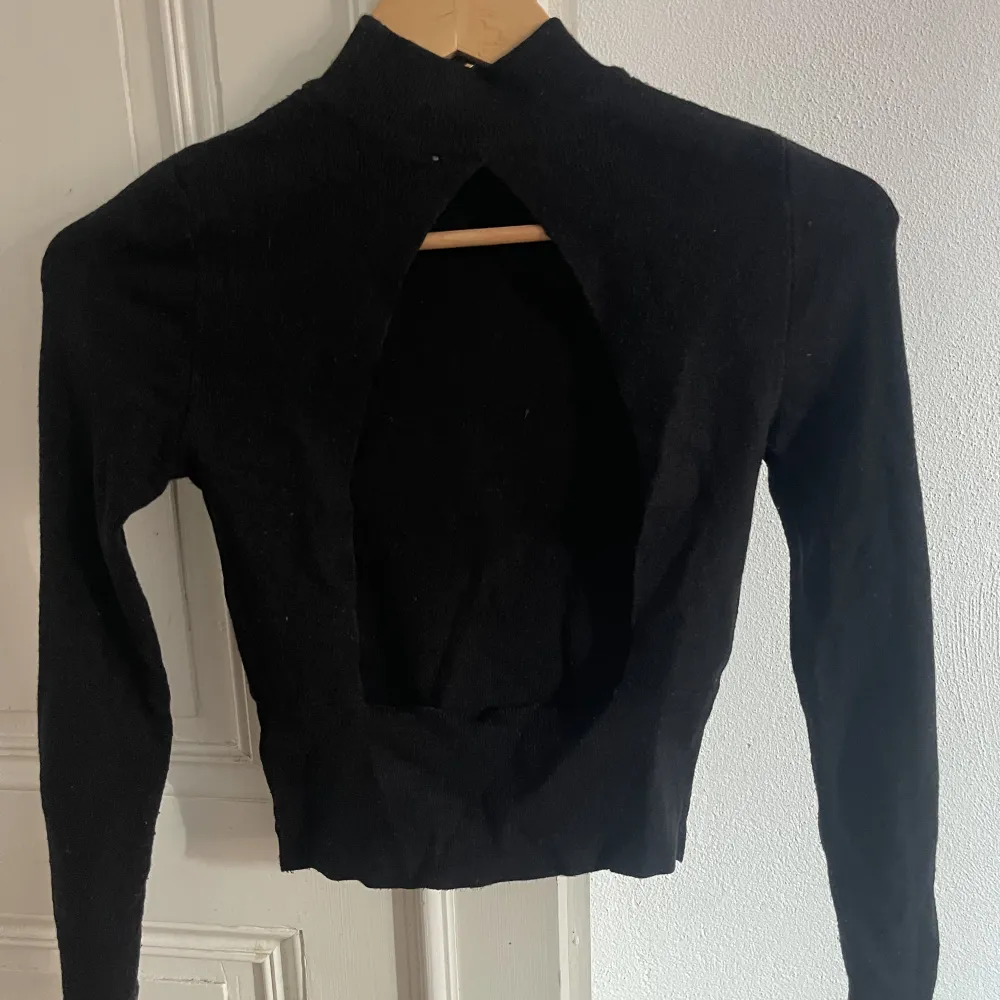 En super fin svart tröja, med öppen rygg, använd några gånger, är lite kortare i storleken vid magen . Toppar.