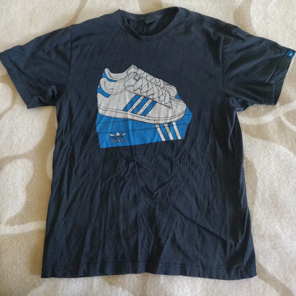 En Adidas vintage t-shirt köpt i Berlin. Tröjan är i bra skick några trådar som är lite lösa i sömmen längs ner på tröjan men inget som syns vid användning går att klippa av och göra en knut eller sy fast tråden. Dm vid frågor✨. T-shirts.