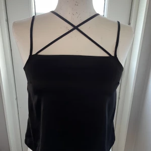 Svart topp - En jättesnygg topp från H&M. Den är i glansigt material. Den passar större än st 34. 
