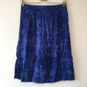 Tiedye Kjol - Sommar kjol med mörkblå tiedye. Stretchig med dragkedja där bak. Köpt secondhand.