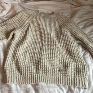 Stickad Tröja - Vit långärmad stickad tröja i storlek M. Den är både snygg och skön.