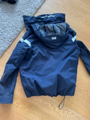Helly Hansen jacka - Säljer billigt då jag reser bort på tisdag så passa på.  Helly Hansen seglarjacka med ett nypris på 2,5k storlek syns på bilden mitt pris 120kr.  Skick 6,5/10