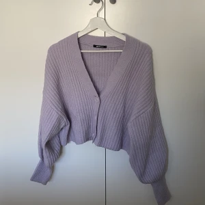 Stickad kofta med ballongärm - Lila stickad kofta med ballongärm, ganska kort modell.