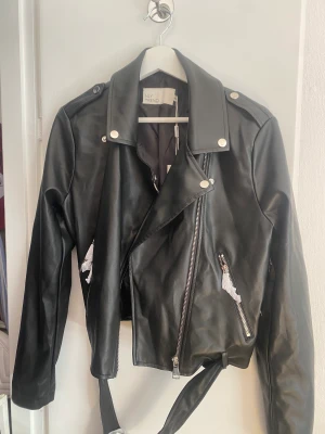 Skinnjacka  - Skinnjacka från Nelly. Aldrig använd, lapp kvar. Storlek 40. Nypris 650kr.