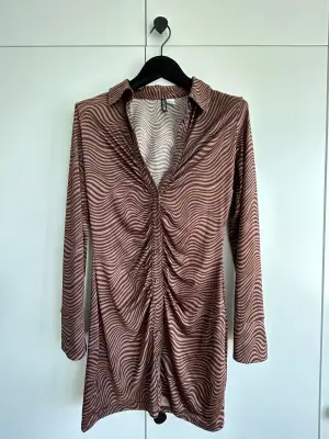 Long sleeved body con, patterned dress. Button-up and stretchy material. Perfect for a night out. 