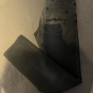 Nudie jeans grim tim - Fina nudie jeans, modellen grim tim i strl 32/34. Jeansen är inköpta på NK.