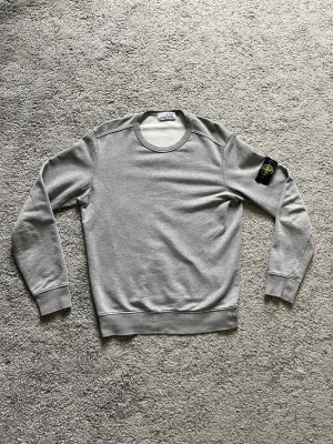 Stone Island Sweatshirt - En stone island sweatshirt i använt men bra skick säljes.  Finns två små skador som man ser på bild.  Bara att skriva till mig om du vill ha bild på QR koden.