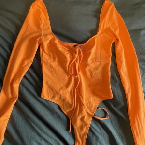 Neonorange body med snörning - köptes på hm för några månader sedan men aldrig använt då jag insåg att jag hade en liknande till🥰perfekt skick!