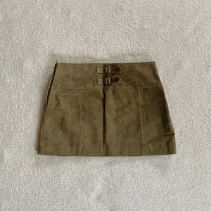 Mockakjol - Grön minikjol i mocka med spännen baktill och dragkedja i midjan, vintage ONLY! Midjemåttet är 72 cm och längden 31 cm (lite för liten för mig) 💓