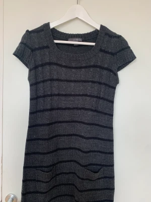 Kort stickad klänning - En kort stickad klänning som är svart och grå randig! Aldrig använd och i bra skick❤️Skirv för fler bilder