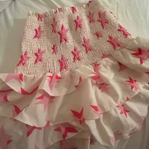 Snygg vit kjol med rosa stjärnor! Strl XS men mkt stretchig! Använd en gång 