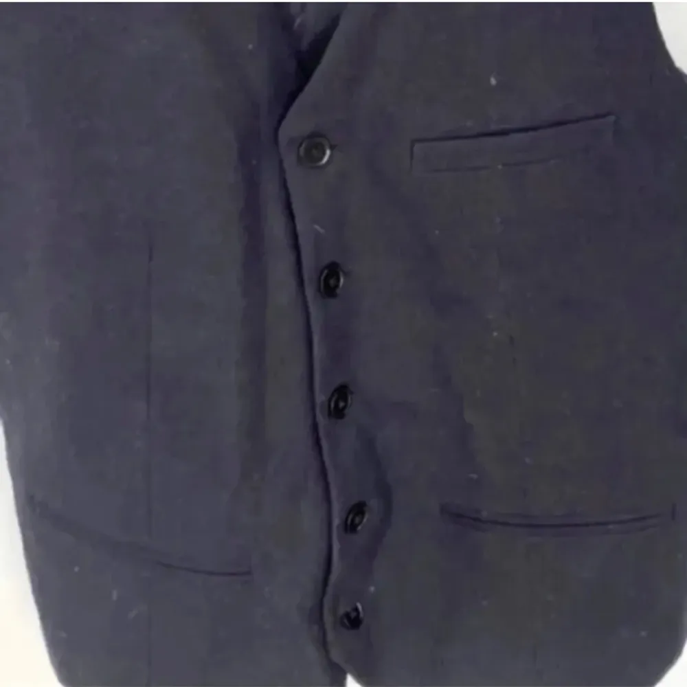 En marinblå kostymväst i nyskick då den bara blivit använd en gång. Man kan justera den med ett spänne på baksidan. Köpt från herravdelningen (storlek 44) Jag har vanligtvis XS/S som referens. Nypris 399kr. . Kostymer.