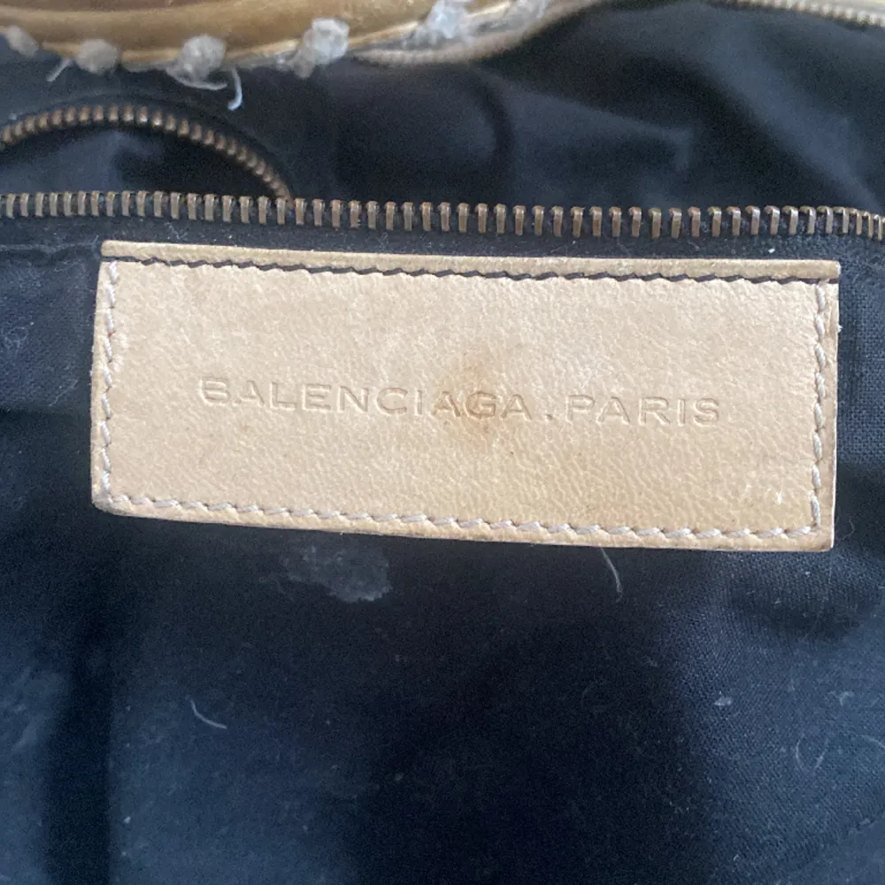 Säljer denna beiga Balenciaga väska köpt på vesteire colective i sommras och fick den äkthetsbevisad då måtten är ca 34x 14 den är lite sliten på handtaget men ingen dragkedja eller nåt sånt är sönder. Väskor.