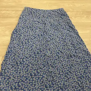 Säljer denna super fina blå blommiga kjol från shein då den inte passar längre. Den har även ett litet slitt vid benet. Nypris runt 100kr nu 50kr