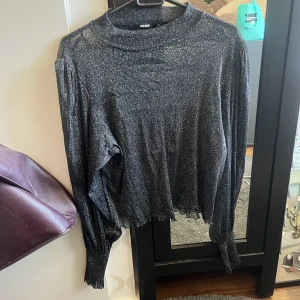 Glittrig Meshtopp - Glittrig meshtopp med bredare axlar. Smalnar av vid händerna. Köparen står för frakten!