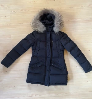 Hollies Wilma Down jacket - Säljer en Hollies Wilma Down jacket. Använd fåtal gånger så jackan är i nyskick. Avtagbar äkta tvättbjörnspäls Strl 36 😊 Nypris 4495kr, mitt pris 2500kr