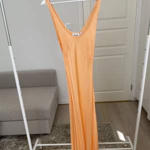 Orange/korall Maxiklänning från weekday i mjukt silky material med lite stretch. Storlek 42.
