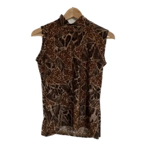 Linne med halvpolo  - Najs linne med halvpolo och blom/djurmönster. Passar bäst på en S/M men har stretch. 