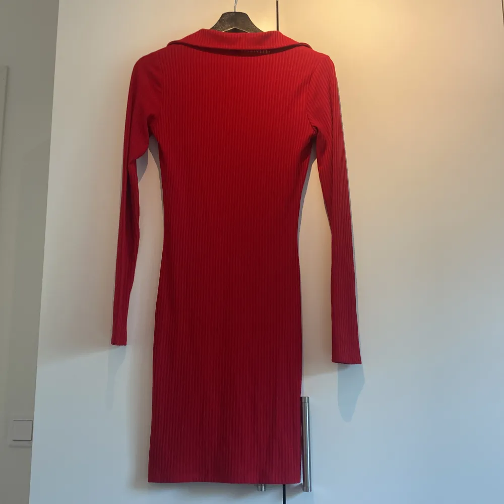 En röd ribbad klänning med krage från NLY trend i storlek XS. Köpte den för att ha den till jul men den kom aldrig till användning så därför har jag valt att sälja den. . Klänningar.